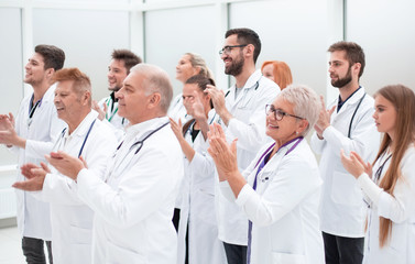 large group of medical practitioners applauding together.
