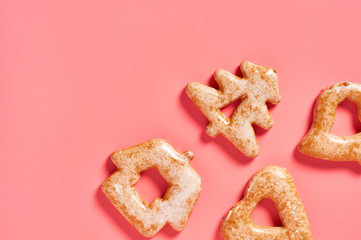 Various festive christmas cookie scattered on pink background. New year celebration concept
