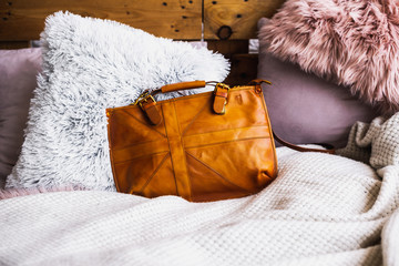 Leather yellow bag on textile background