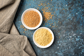 Set of yellow mustard sauce and seeds in small bowls