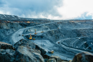 Work of trucks and the excavator in an open pit - obrazy, fototapety, plakaty