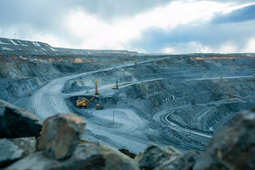 Work of trucks and the excavator in an open pit