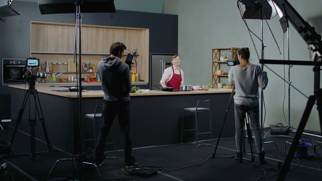 WIDE Behind the scenes of studio set, shooting TV television cooking show featuring celebrity chef, professional TV production