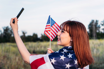young girl making a self portrait celebrating independence day and having fun with the national flag of the United States