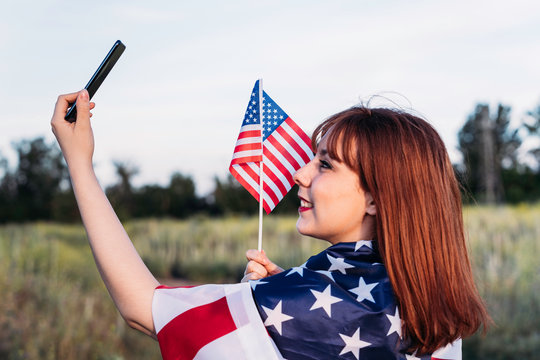 young girl making a self portrait celebrating independence day and having fun with the national flag of the United States