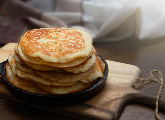 Delicious sweet american pancakes in a hot pan on the table. Gourmet breakfast. Selective focus