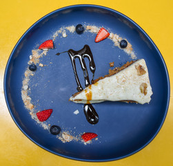 Carrot cake with walnuts, icing sugar and red fruit decoration photographed from close up