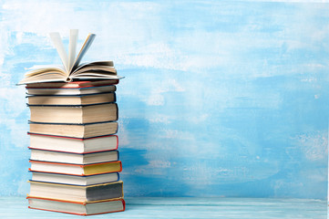 Composition with vintage old hardback books, diary, fanned pages on wooden deck table and abstract background. Books stacking. Back to school. Copy Space. Education background.