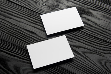 Business card blank on black wooden background. Corporate Stationery, Branding Mock-up. Creative designer desk. Flat lay. Copy space for text