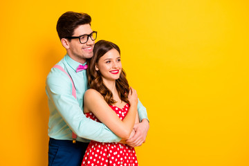 Profile photo of attractive pretty lady handsome guy couple hugging look side empty space wear red dotted dress shirt bowtie retro clothes isolated yellow bright color background