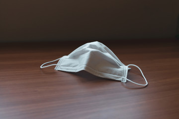 Corona virus prevetion face mask protection. Medical surgical masks on a desk. Wood background.