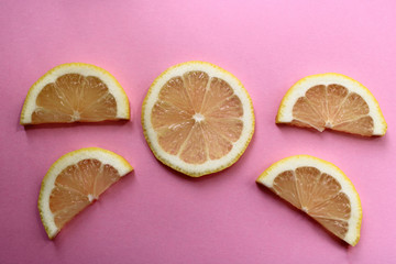 lemon slices lie on a pink background
