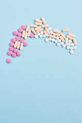 medicine concept. vitamins and pills to maintain healthy skin and hair. simple flat lay on a blue background, space for text