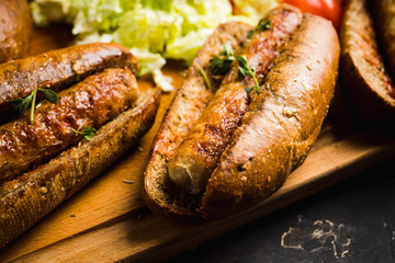 Tasty fresh hot dogs with grilled sausage on the rustic background. Selective focus. Shallow depth of field.