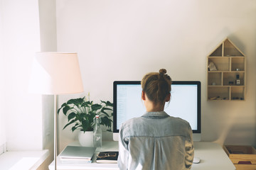 Woman working on computer at home office.