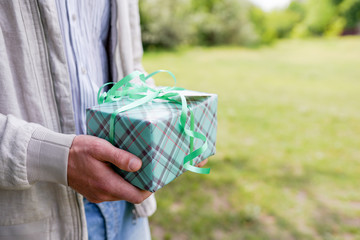 A man holding a green gift box , background with copy space