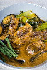 kare kare; a mix of ox tail and tripe with vegetables like eggplant, sitaw (long bean), pechay, puso ng saging stewed in peanut sauce and serve with shrimp paste for additional flavor