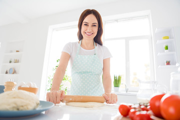 Obraz na płótnie Canvas Photo of beautiful cheerful housewife enjoy hobby preparing family recipe dinner forming making dough use rolling pin hands modern kitchen indoors casual clothing