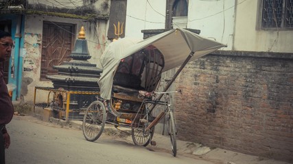 Fototapeta na wymiar rusty trishaw with white cloth on top parked