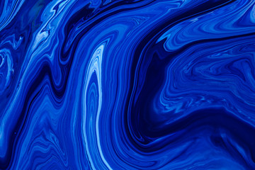 Fluid art texture. Background with abstract mixing paint effect. Liquid acrylic artwork with flows and splashes. Classic blue color of the year 2020. Blue, white and indigo overflowing colors