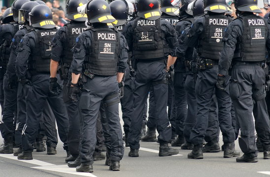 Schwarz uniformiertes Polizeiaufgebot in voller Ausrüstung auf einer Demo