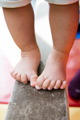 a 10th month old baby feet balancing on balance beam