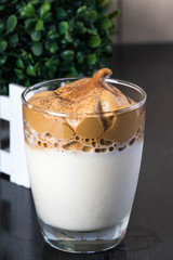 dalgona coffee is a whipped coffee and sugar on topped of ice cold milk