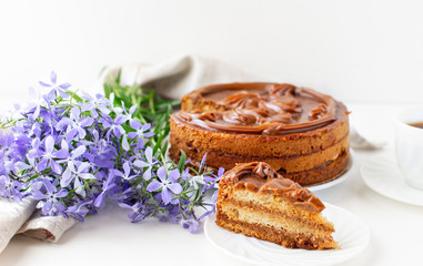 Homemade honey cake decorated with caramel on a light background. Home baking concept.