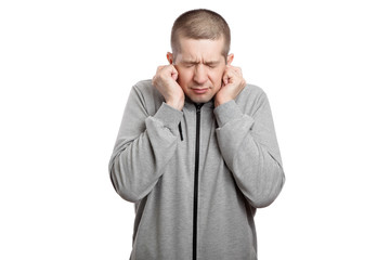 Naklejka premium cowardly frightened man covered his ears with his hands, squeezed with fear. Dressed in sportswear. Isolated