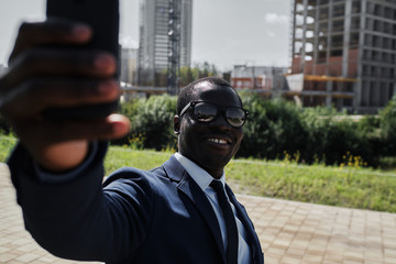 African businessman taking selfie with smart phone outdoor
