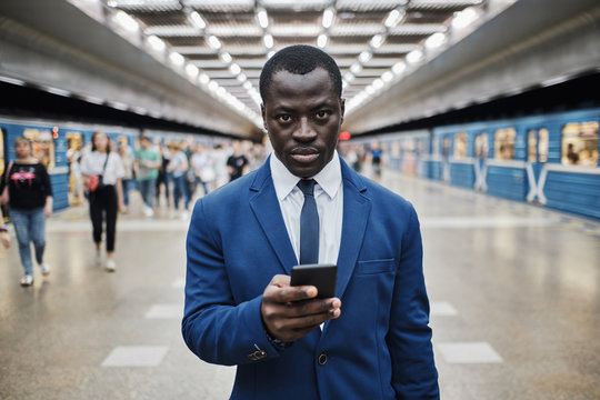 African businessman with smart phone at subway station
