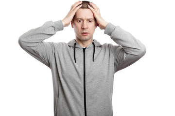 disillusioned, distressed man clutched his head in surprise. Dressed in sportswear. Isolated