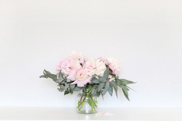 Peonies in the interior on the table.
