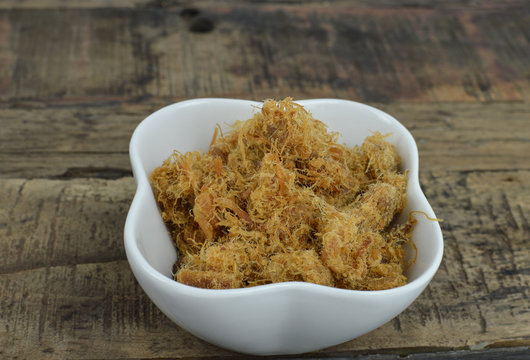Fried Pork greaves, cracklings,  duvan cvarci, in a white bowl on the rustic wooden table