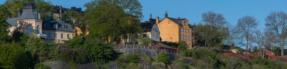 Fototapeta na wymiar Sunny morning view over old house part of the district of Södermalm, above the waterfront at the bay Riddarfjärden and the sluice part in Stockholm. 