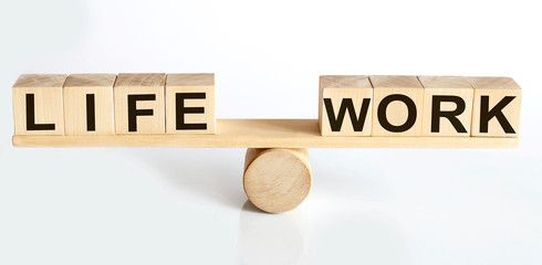 Wooden seesaw representing imbalance between Life and Work isolated over white background