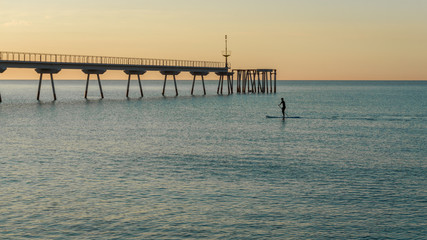 Obraz premium young boy doing paddle surf in the sea
