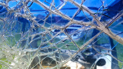 The broken windshield of the car. Glass splinter. An accident with the car. Dangerous traffic accident. Road accident. Glass background.
