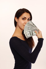 Portrait of young pretty woman with dollars over her face over white background