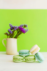 Bright picture of colorful different macaroons with flowers nearby