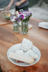 Cheese platter on wooden table outdoors. Family celebration in the garden