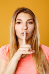 Young pretty blond woman showing silence sign over yellow background