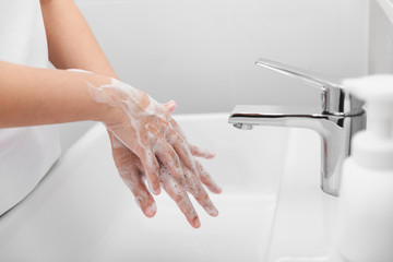 Woman use soap and washing hands under the water tap for corona virus prevention.
