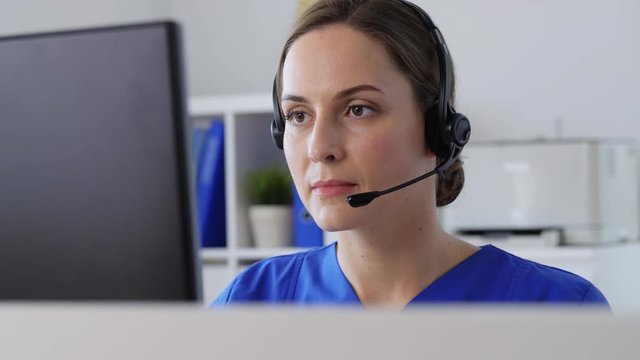 medicine, technology and healthcare concept - female doctor or nurse with headset and computer working at hospital