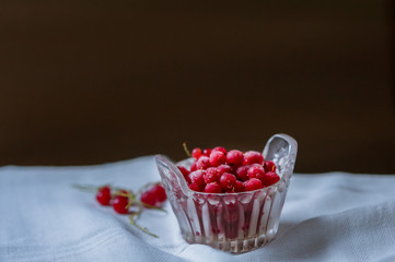 Frozen redcurrant berries in a glass vase. Close-up. Theme of wholesome nutrition, diet desserts.
