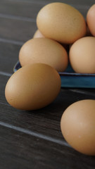 a pile of eggs on a plate and  two eggs on the table