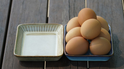 an empty plate, and a plate full of eggs on the table