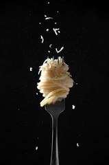 Fork with Spaghetti Sprinkled Cheese and Pepper on Dark Background. Cacio e Pepe - Italian Pasta