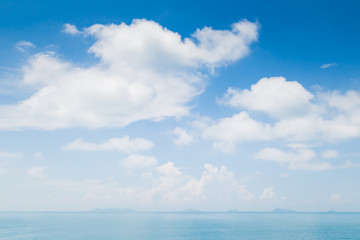 Obraz na płótnie Canvas White fluffy clouds and turquoise sea on blue sky