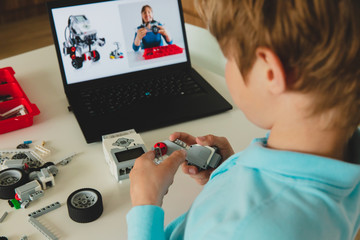 kid building robot with online robotic technology lesson